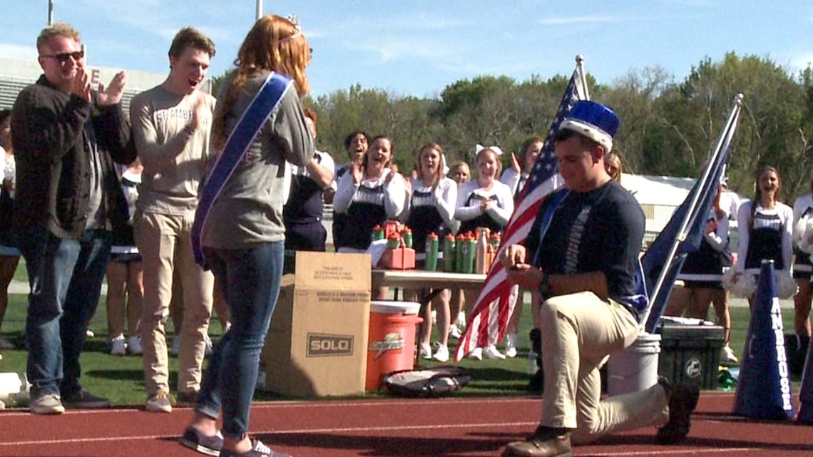 king surprises queen with a proposal at St. Ambrose football