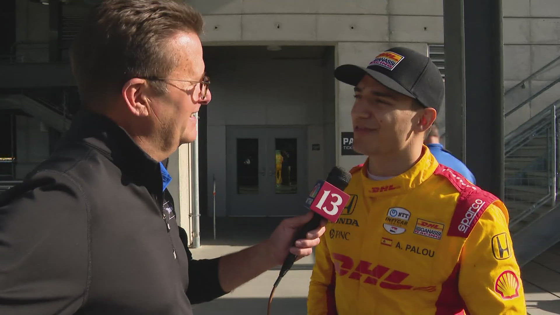 13Sports director Dave Calabro talks with 2024 Sonsio Grand Prix race winner Alex Palou right after the Spaniard got off the podium.