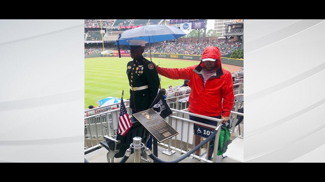 Powerful photo shows Braves fan hold umbrella over JROTC member