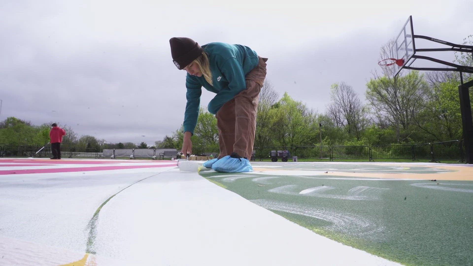 13News anchor Dustin Grove reports from Brooks School Park where local artists are painting basketball courts.