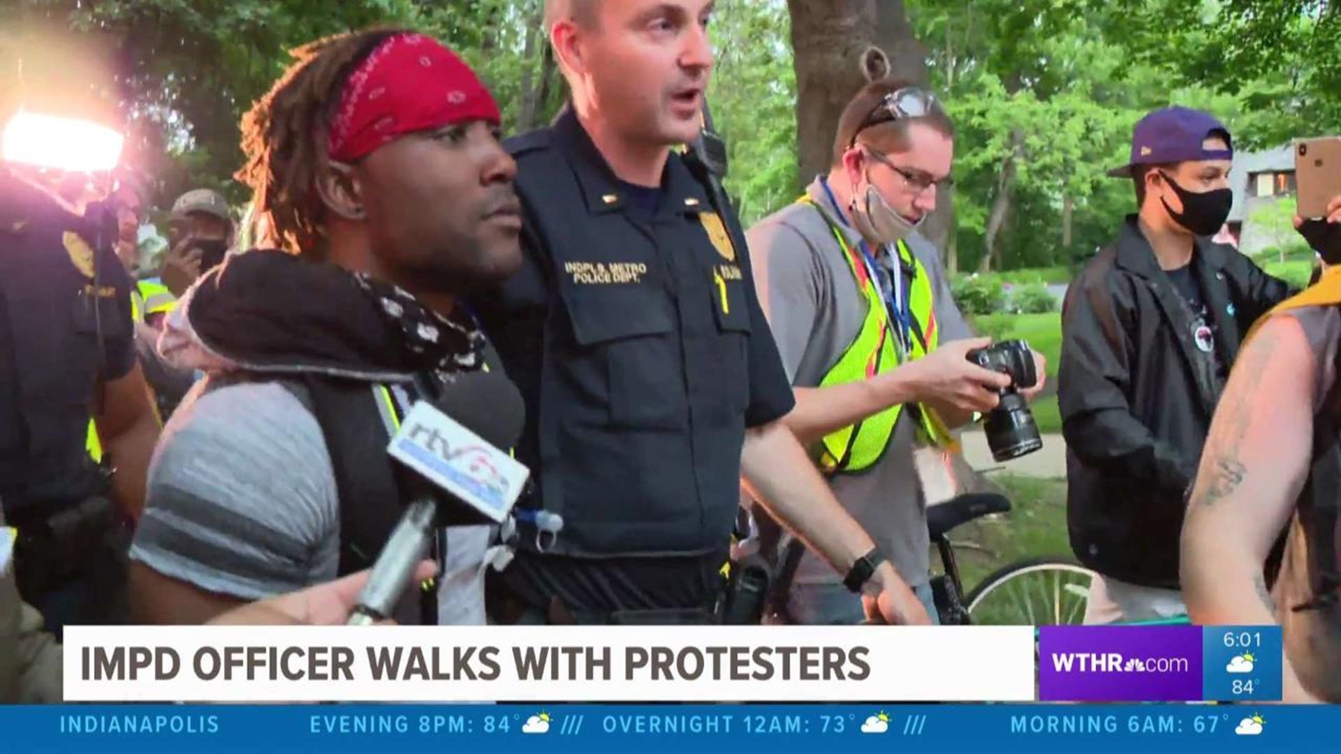 IMPD officer walks with protesters