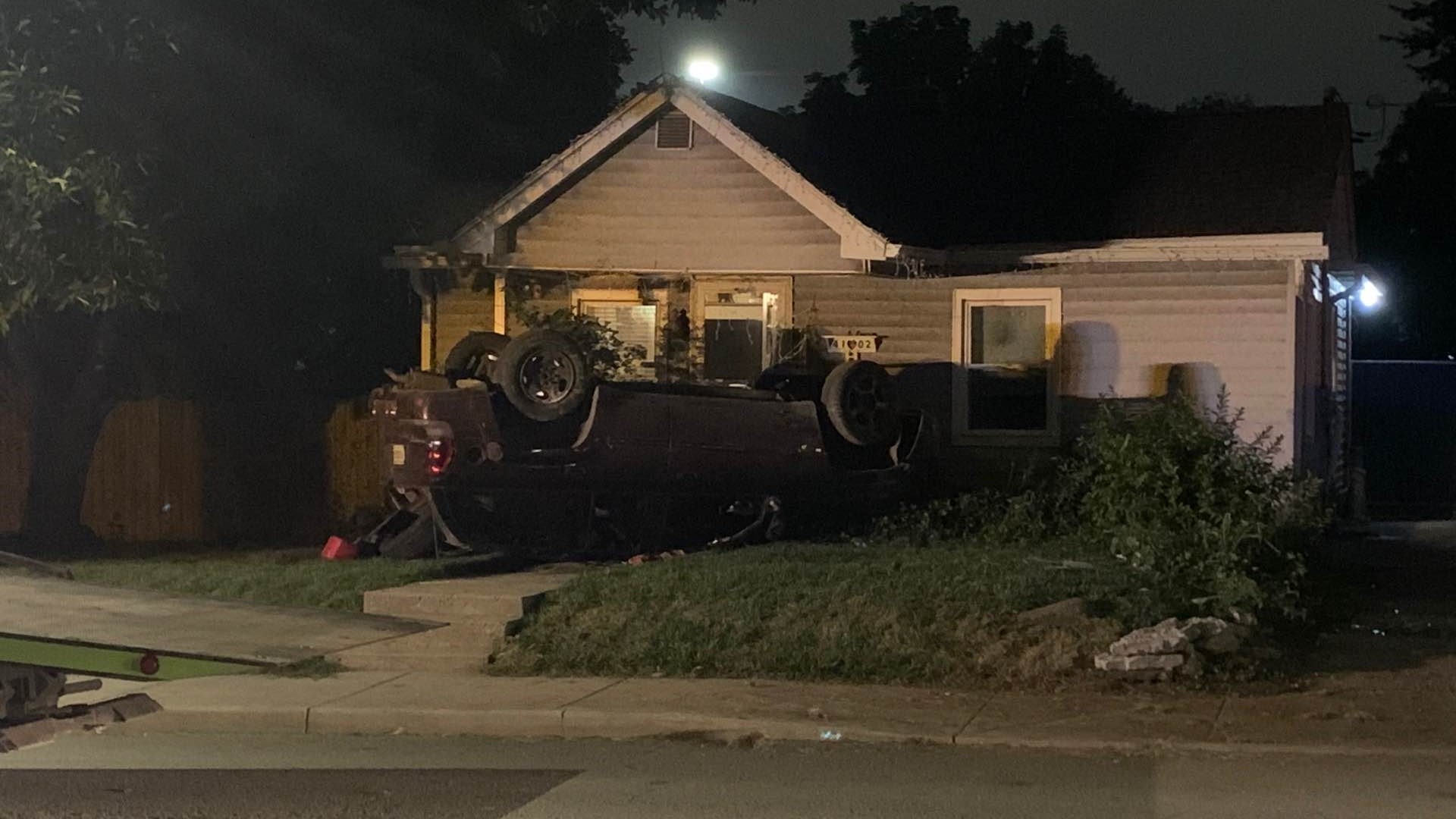 Police said a car rolled over onto a nearby porch during a Monday night crash that killed a woman and left three kids with minor injuries.