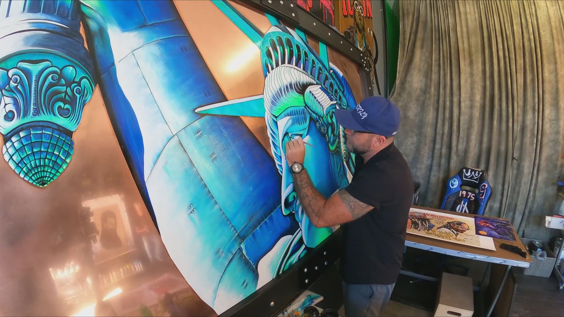 13News reporter Matthew Fultz talks with Marine veteran Gavin Goode as he paints a tribute to those lost in the 9/11 terror attacks.