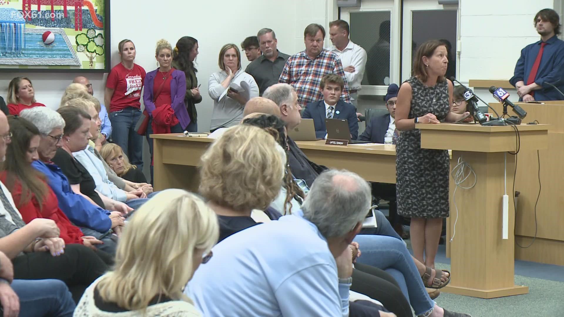 Parents gathered at a board meeting disagreeing with what is being taught outside of the curriculum