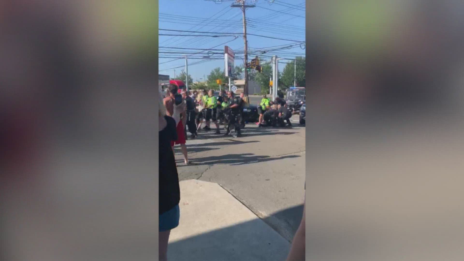 Three people were arrested Sunday after protestors were met with police and dogs after a woman drove through people marching in the street.