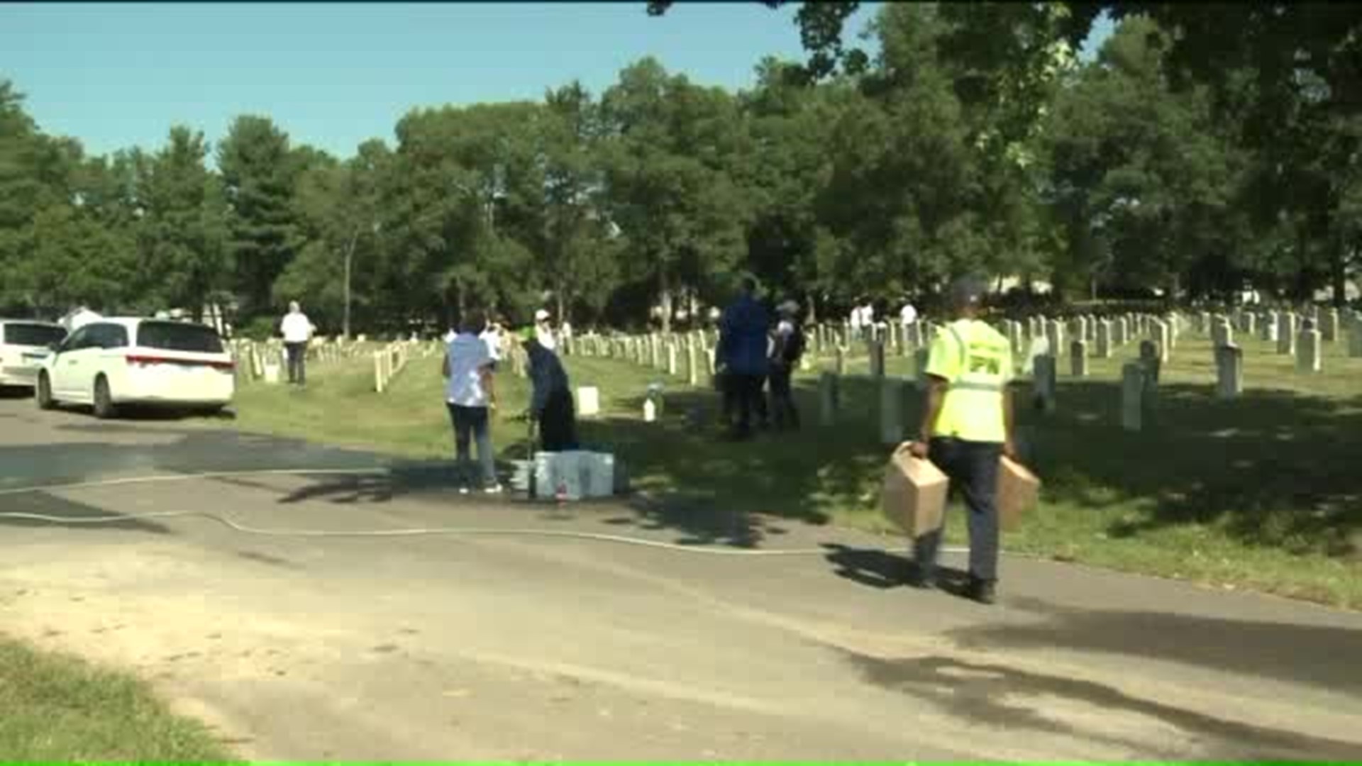 Volunteers clean off dirty veterans' headstones