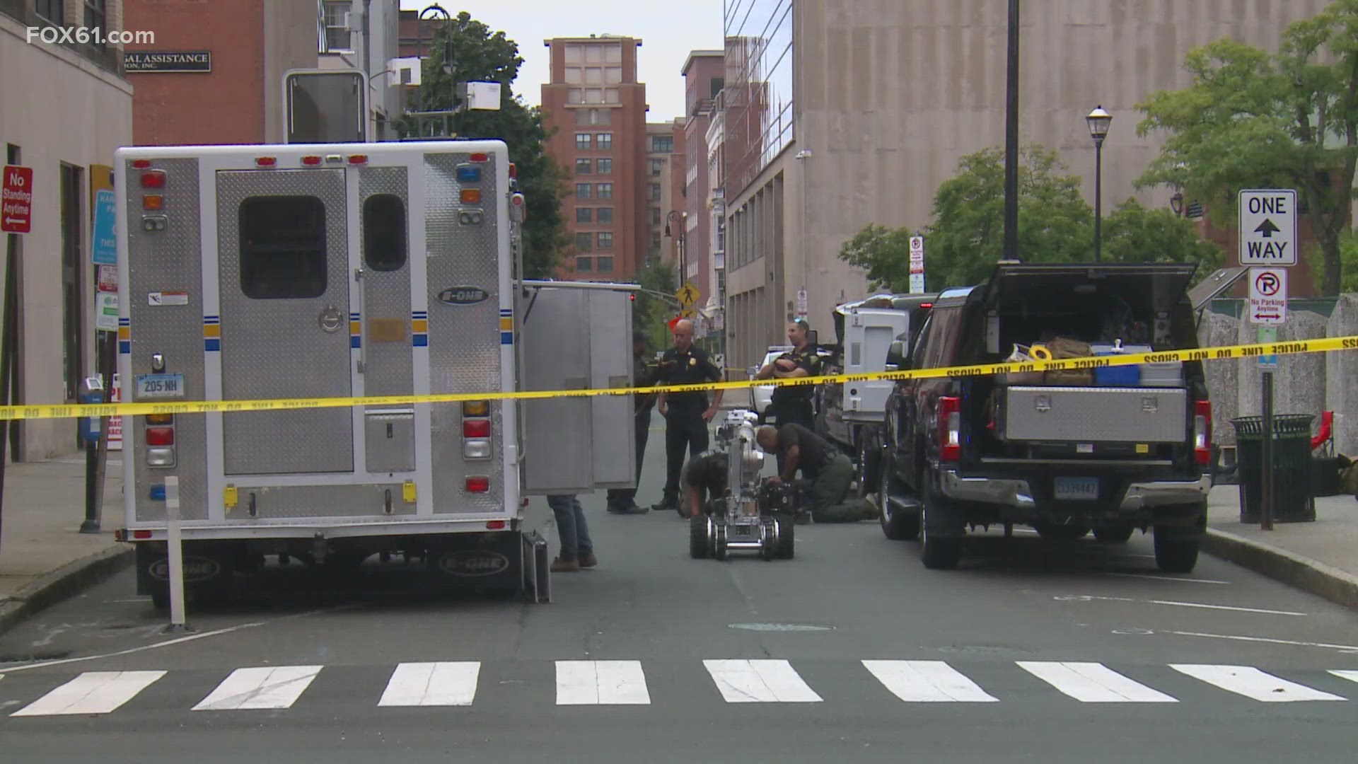 A man is in custody after New Haven police say he threw three suspicious devices near government buildings Friday morning forcing the evacuation of City Hall.