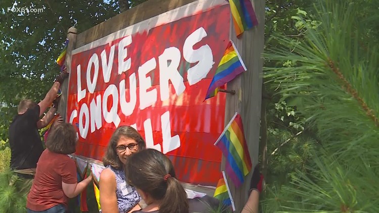 Pride flag sign vandalized in Tolland again, residents gather to repair it