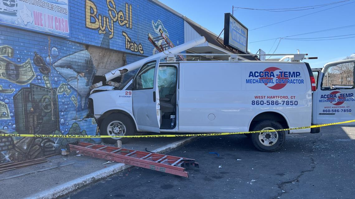 Van damaged after crashing into a pawn shop.