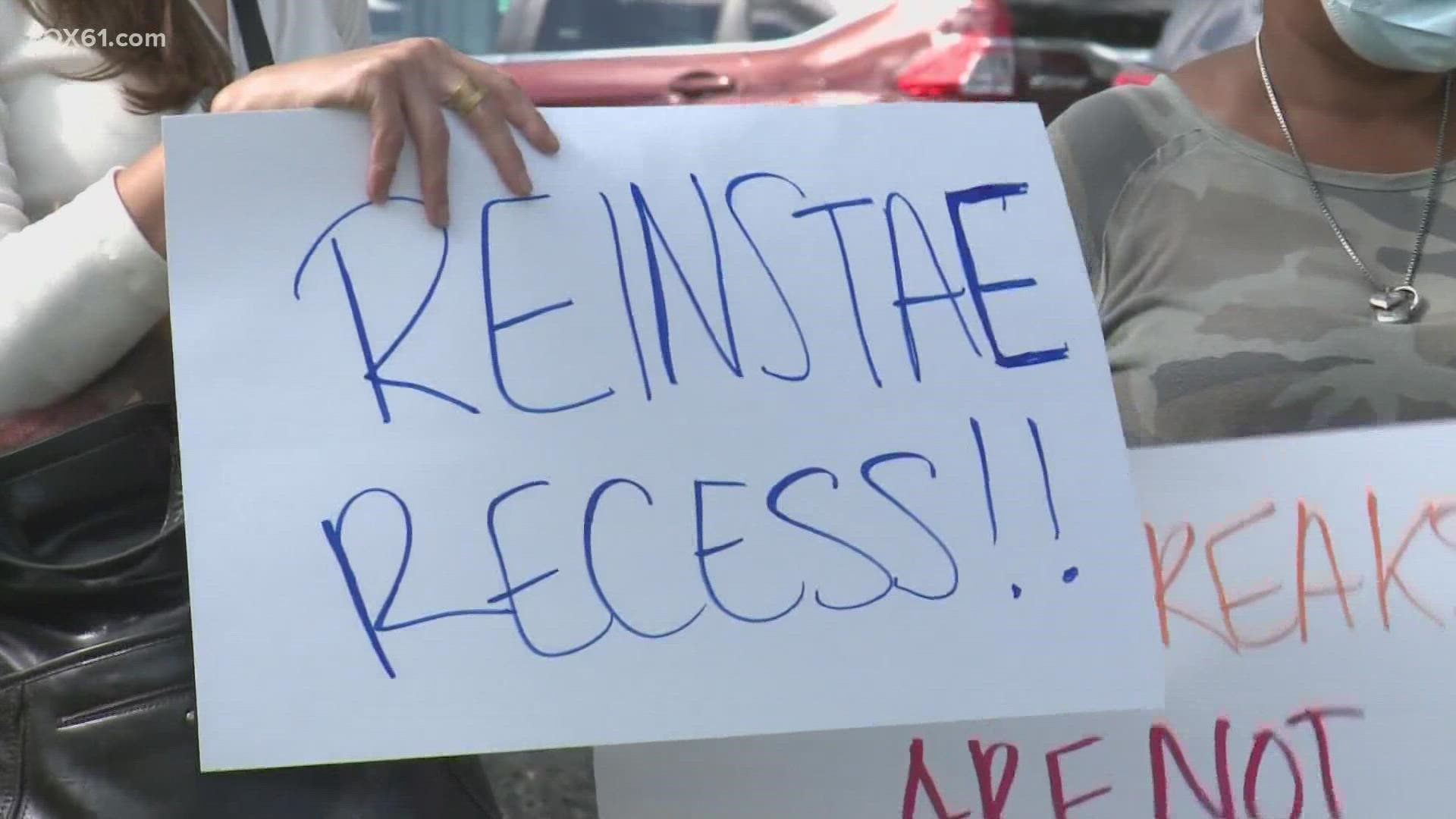 Parents held a rally outside the administration building with signs for kids to have more play time outside, but school officials say it was cut down due to COVID-19