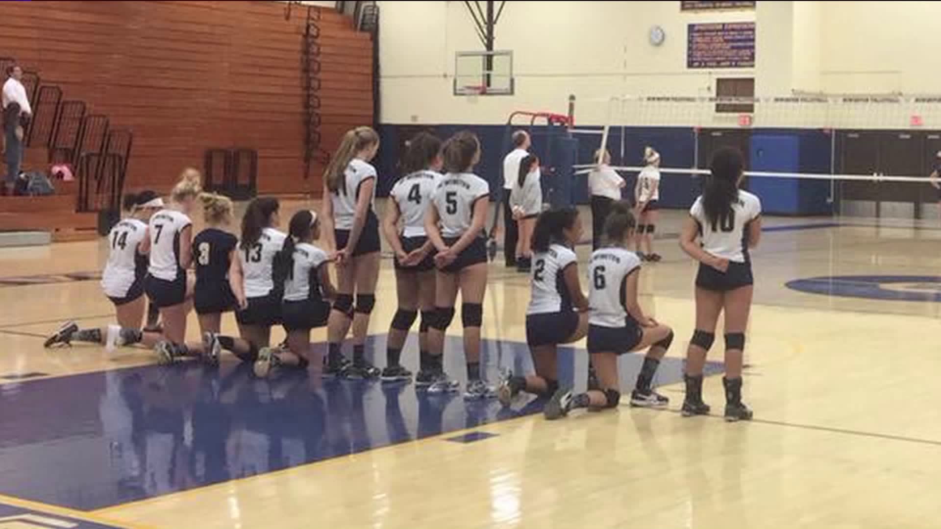 Volleyball team takes a knee during National Anthem
