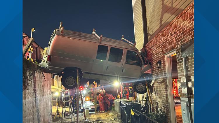Photos: Van suspends in air during crash, gets stuck between retaining wall and Acworth townhome