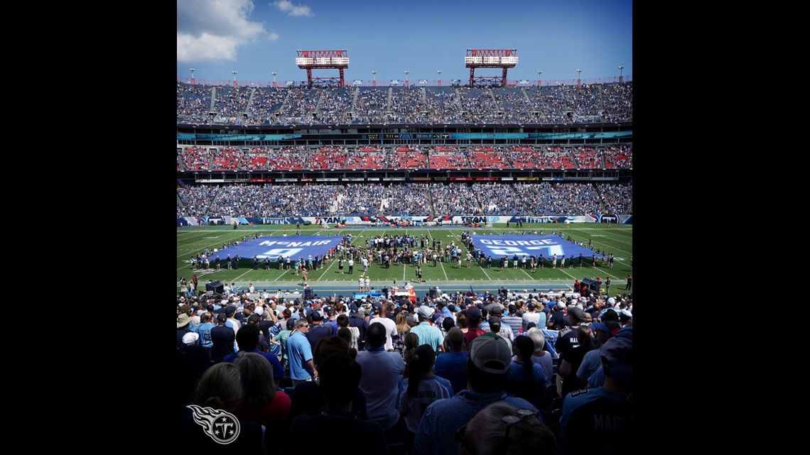 Former Tennessee Titans running back Eddie George, second from left, stands  with family members of the late Titans quarterback Steve McNair, as the  numbers for George and McNair are retired during halftime